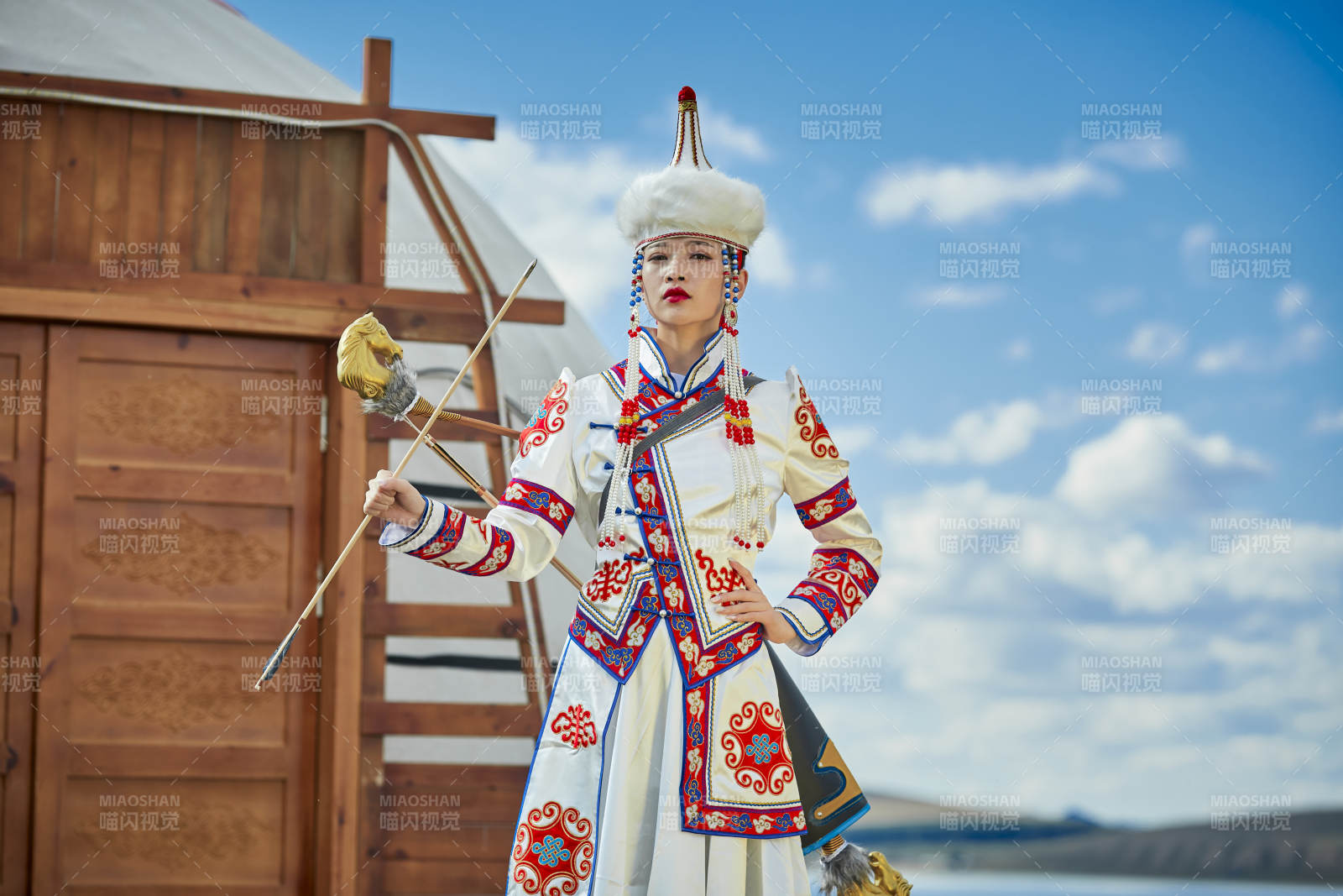 草原湖畔身穿蒙古族饰手持弓箭的蒙族少女图片