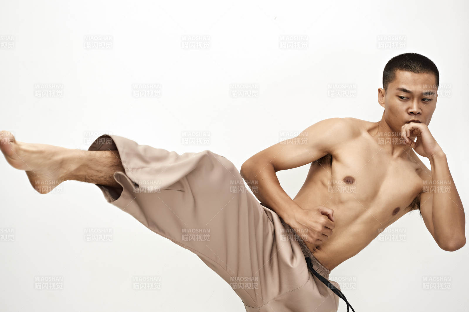 白色背景下演示自由搏击动作的亚洲功夫男性图片