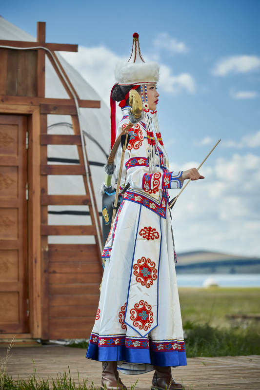 草原湖畔身穿蒙古族饰手持弓箭的蒙族少女图片