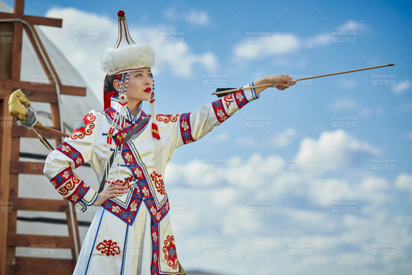 草原湖畔身穿蒙古族饰手持弓箭的蒙族少女图片
