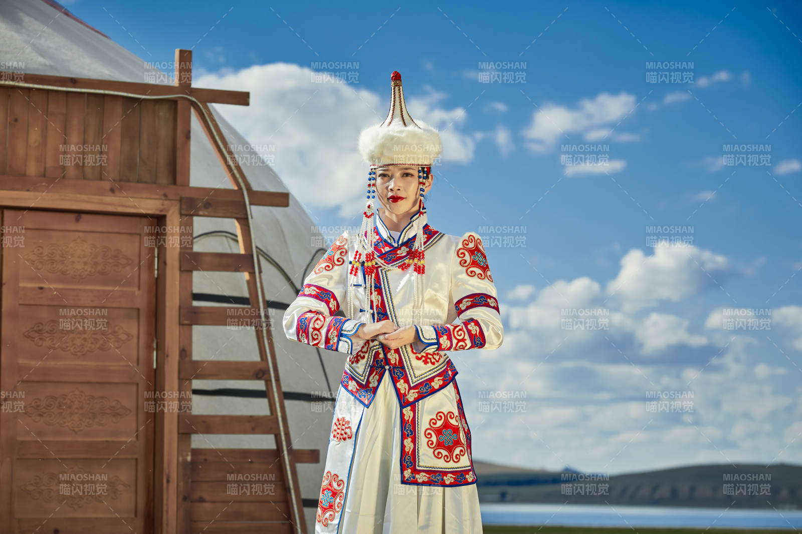 草原湖畔身穿蒙古族饰手持弓箭的蒙族少女图片