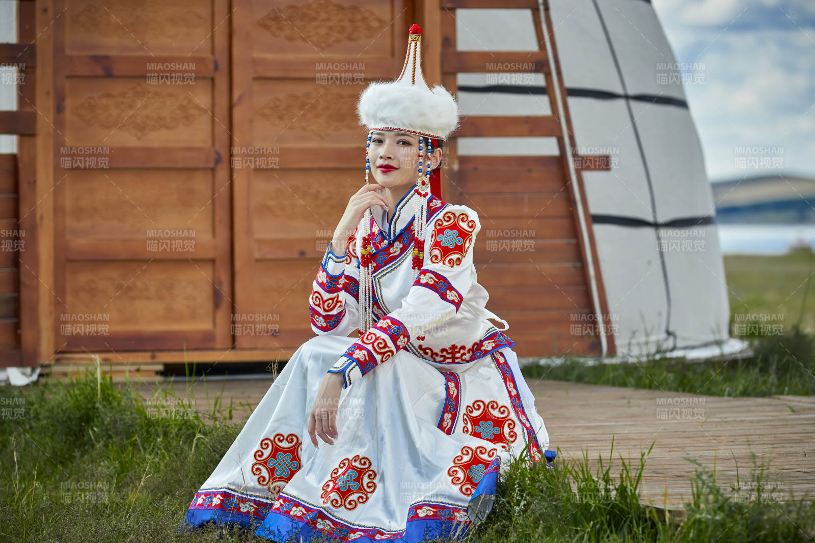 草原湖畔身穿蒙古族饰手持弓箭的蒙族少女图片