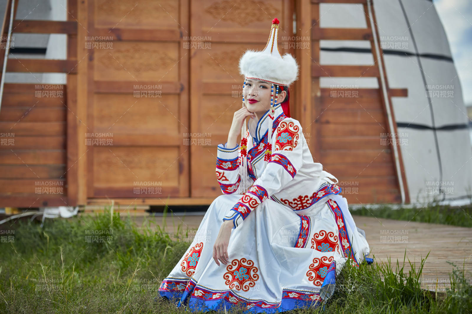 草原湖畔身穿蒙古族饰手持弓箭的蒙族少女图片
