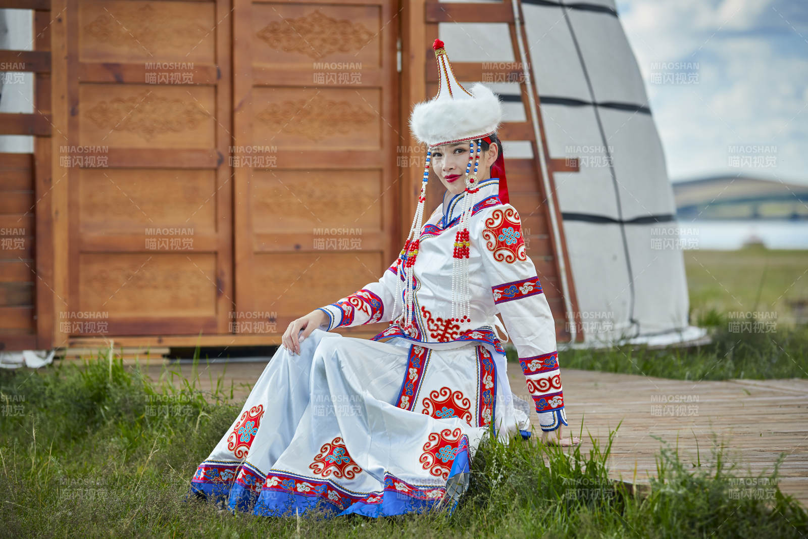 草原湖畔身穿蒙古族饰手持弓箭的蒙族少女图片