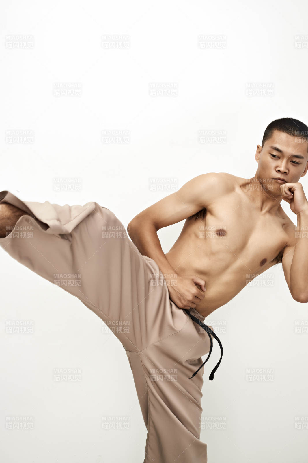 白色背景下演示自由搏击动作的亚洲功夫男性图片