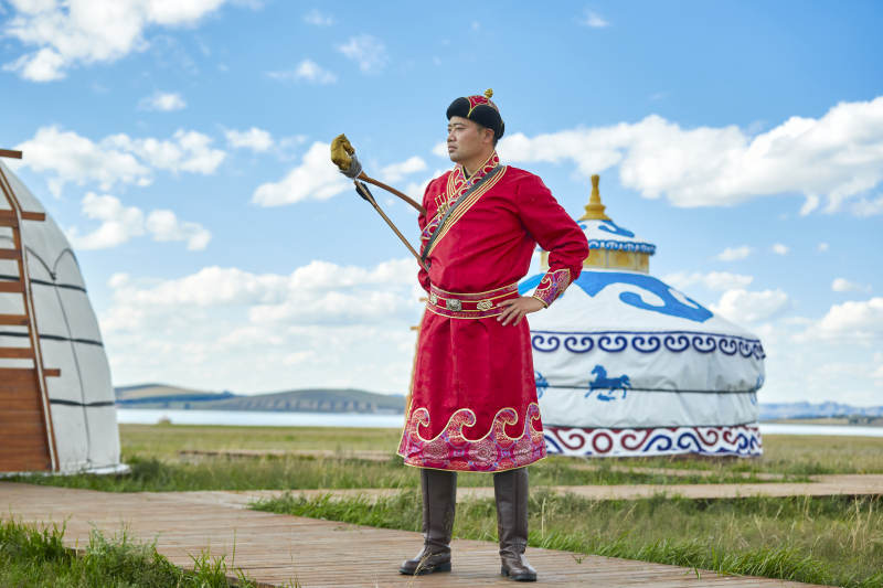 蒙古包前身穿蒙古族饰手持弓箭的蒙族汉子图片