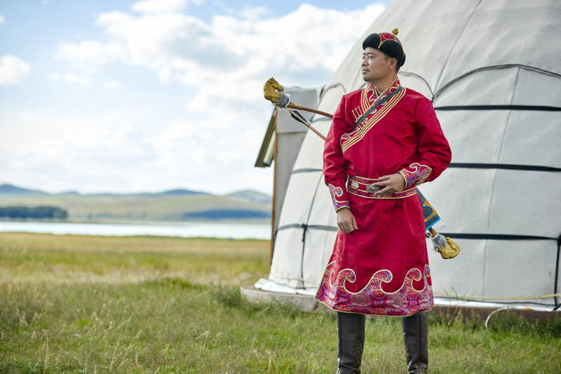 蒙古包前身穿蒙古族饰手持弓箭的蒙族汉子图片