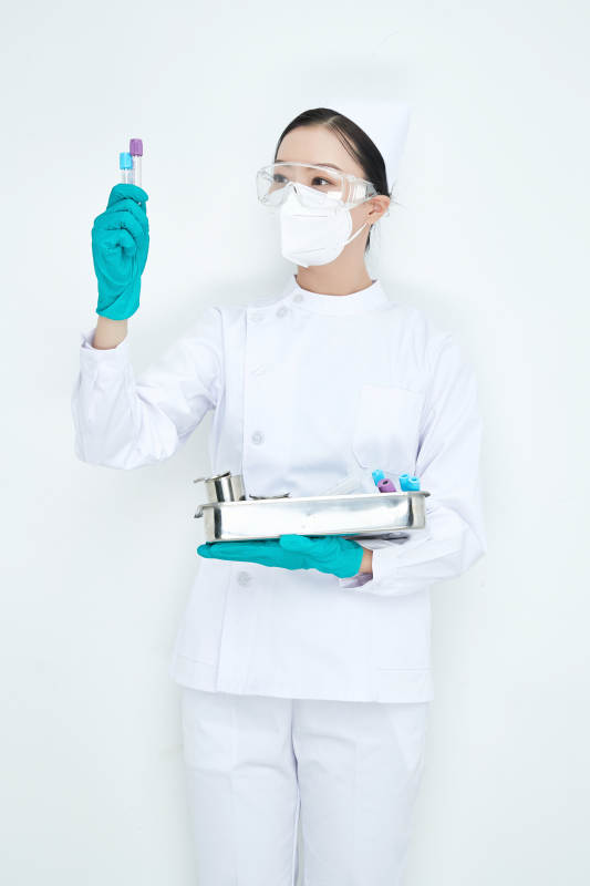 身穿护士服手抱化验托盘的年轻女护士图片