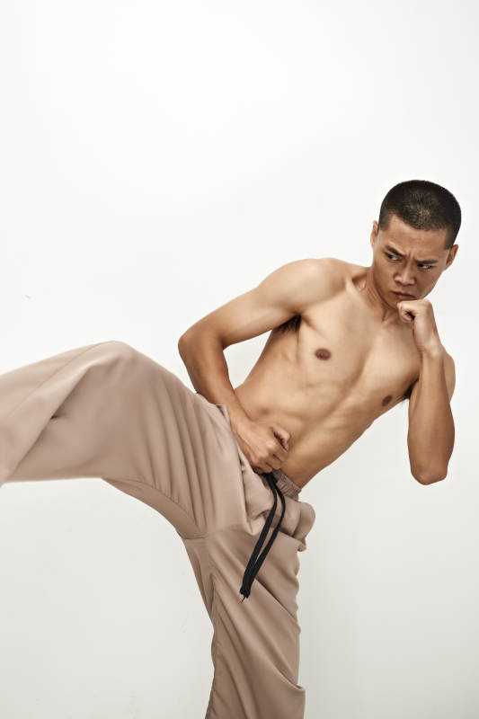 白色背景下演示自由搏击动作的亚洲功夫男性图片