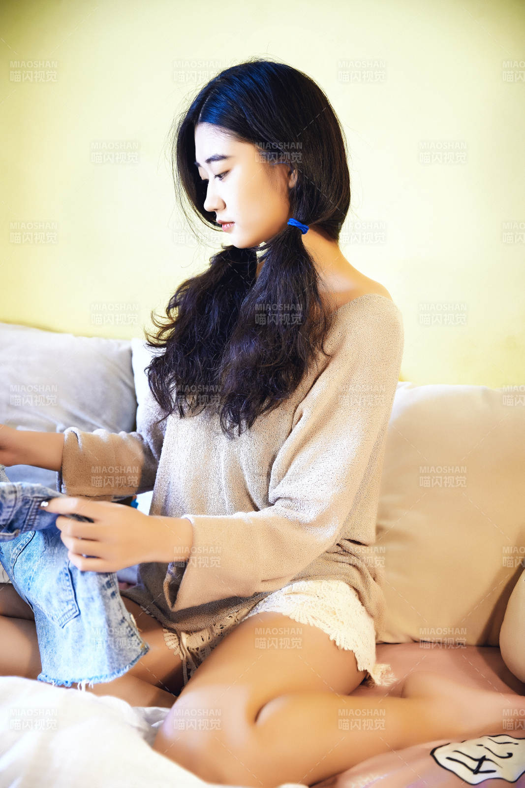 在沙发床上整理行装的年轻亚洲女性图片