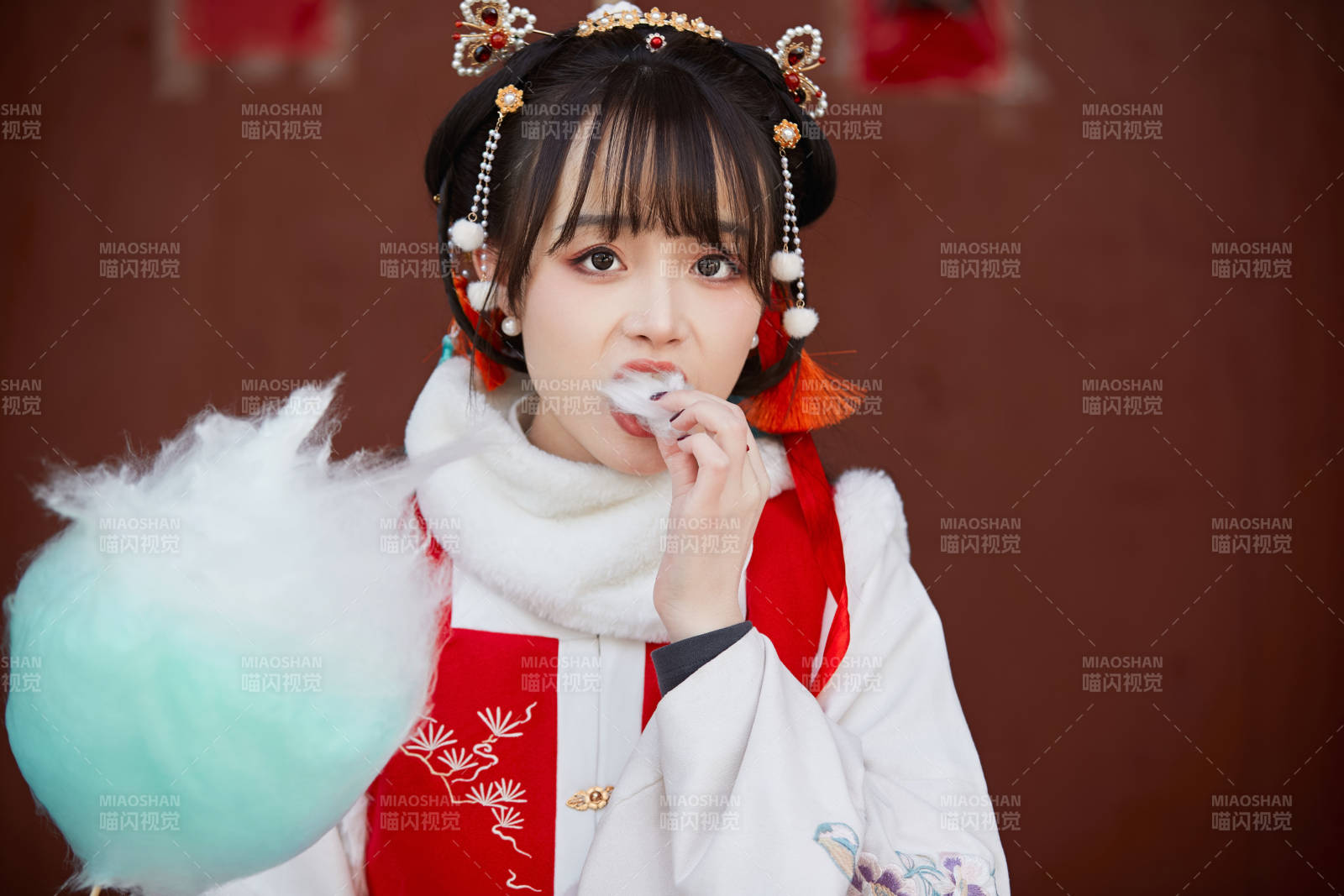身穿喜庆汉服吃棉花糖的少女图片