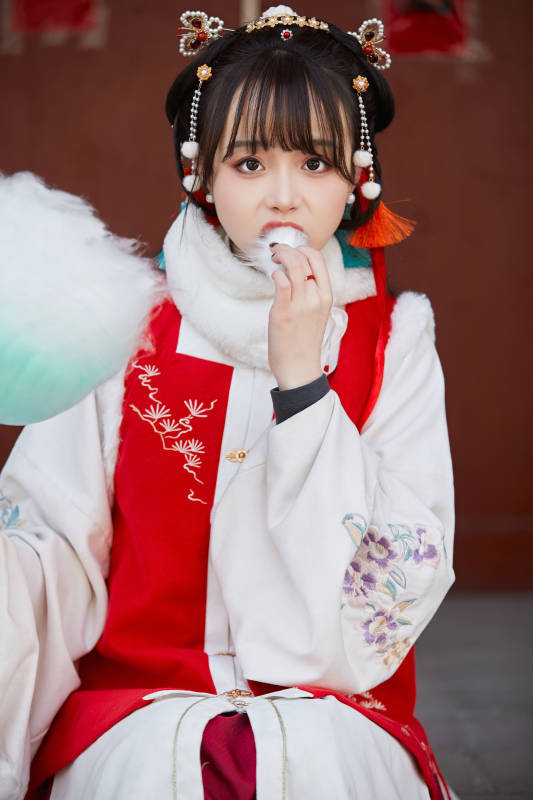身穿喜庆汉服吃棉花糖的少女图片