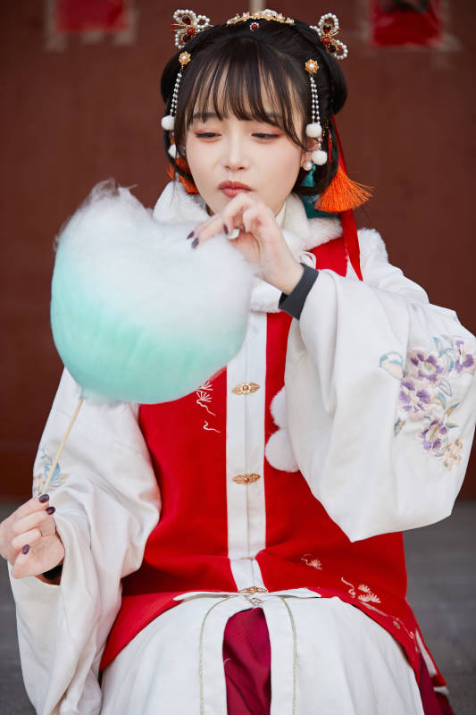 身穿喜庆汉服吃棉花糖的少女图片