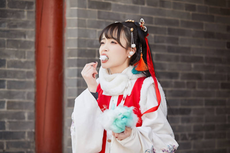 身穿喜庆汉服吃棉花糖的少女图片