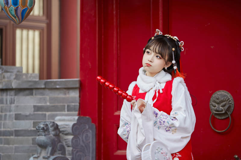 身穿喜庆汉服在古城游玩的少女图片