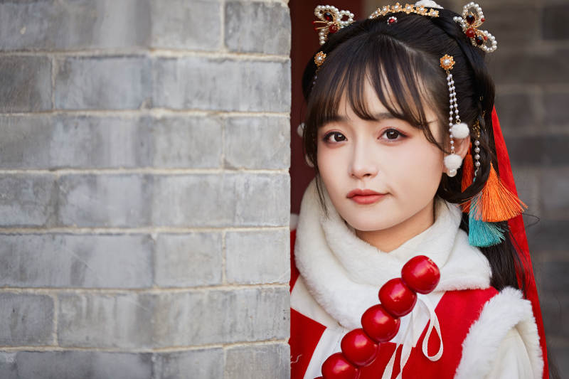 身穿喜庆汉服在古城游玩的少女图片