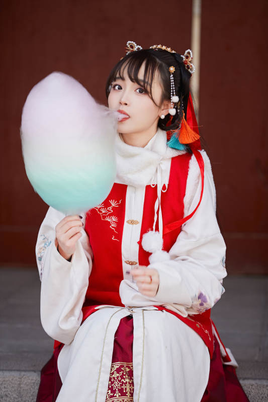 身穿喜庆汉服吃棉花糖的少女图片