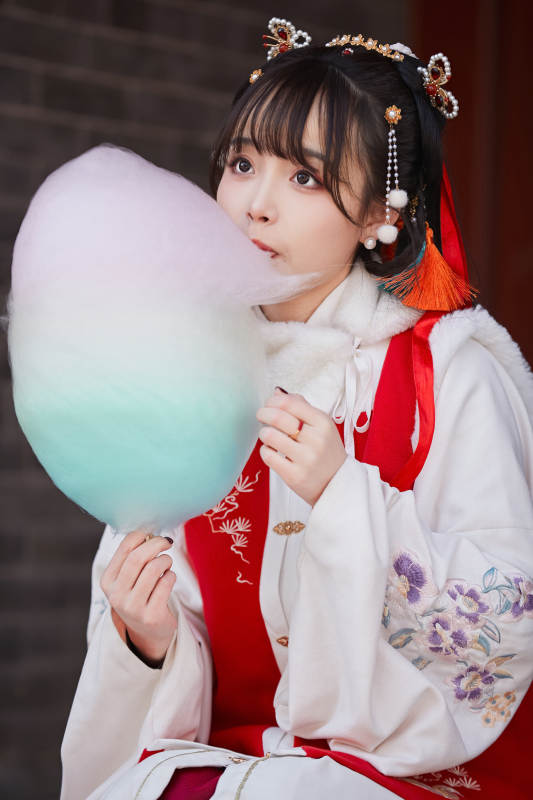 身穿喜庆汉服吃棉花糖的少女图片