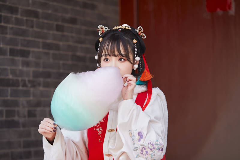 身穿喜庆汉服吃棉花糖的少女图片
