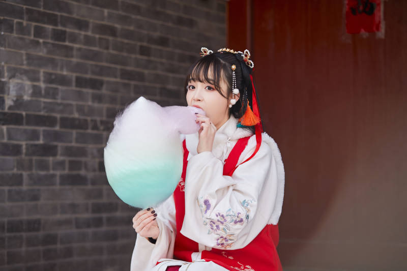 身穿喜庆汉服吃棉花糖的少女图片