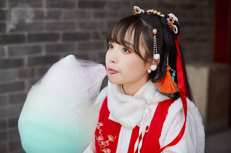 身穿喜庆汉服吃棉花糖的少女图片