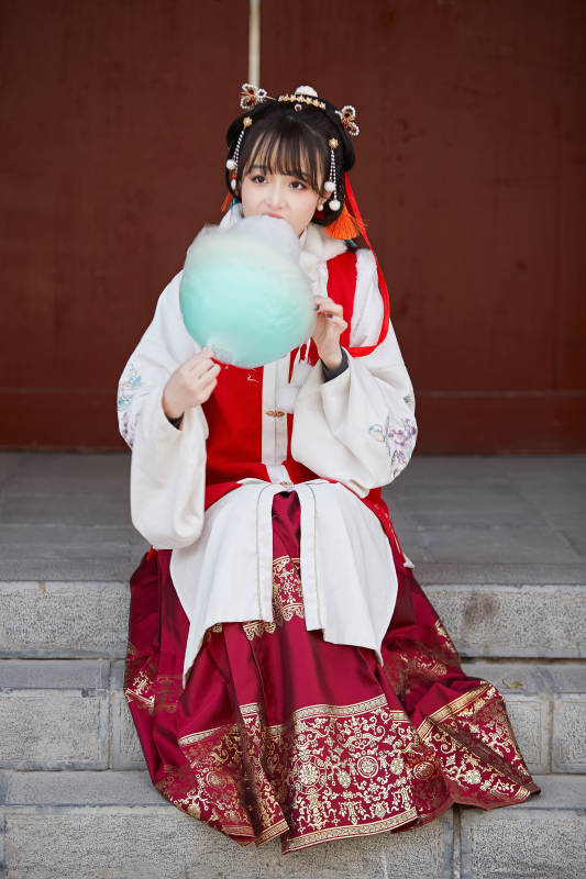身穿喜庆汉服吃棉花糖的少女图片