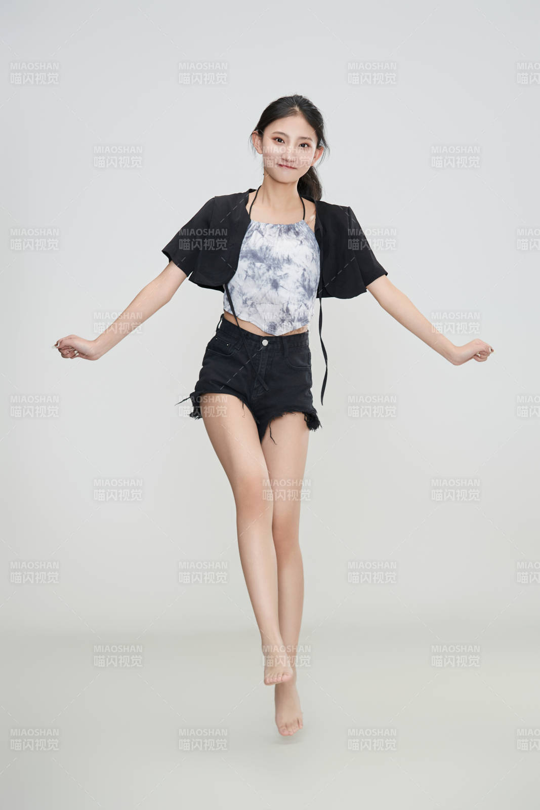 白色背景下腾空跳跃的可爱亚洲少女图片