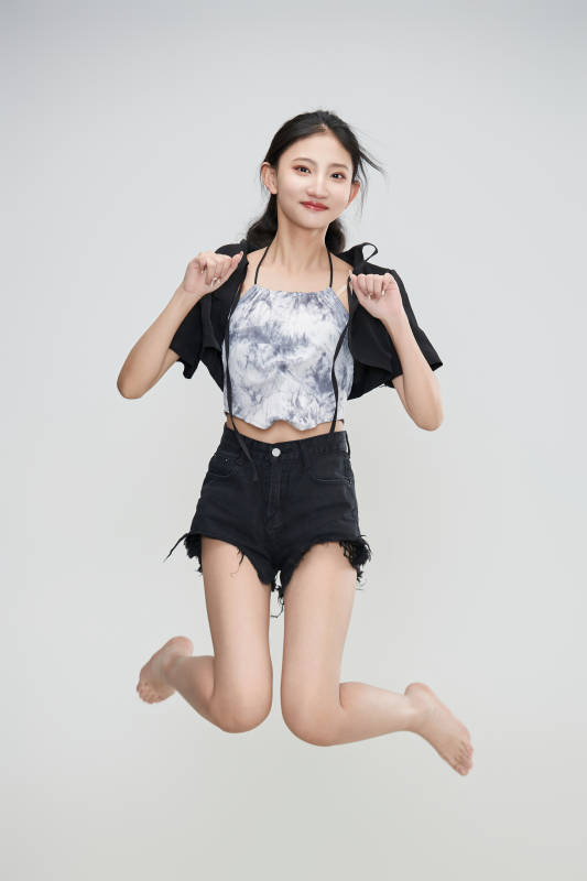 白色背景下腾空跳跃的可爱亚洲少女图片