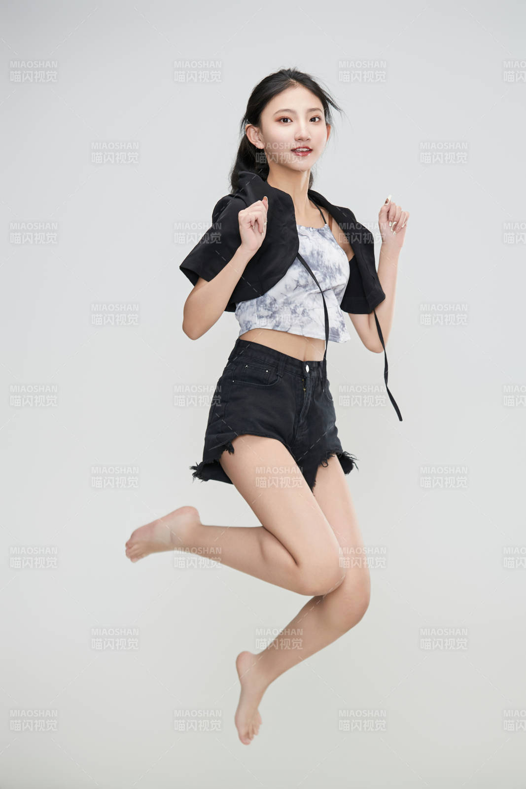 白色背景下腾空跳跃的可爱亚洲少女图片