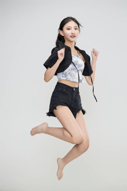白色背景下腾空跳跃的可爱亚洲少女图片