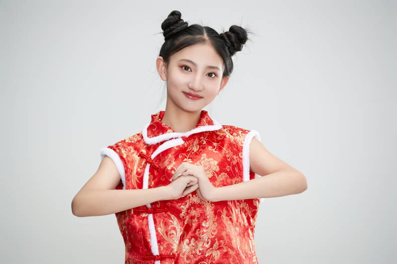 白色背景下身穿喜庆传统服饰的亚洲可爱少女图片