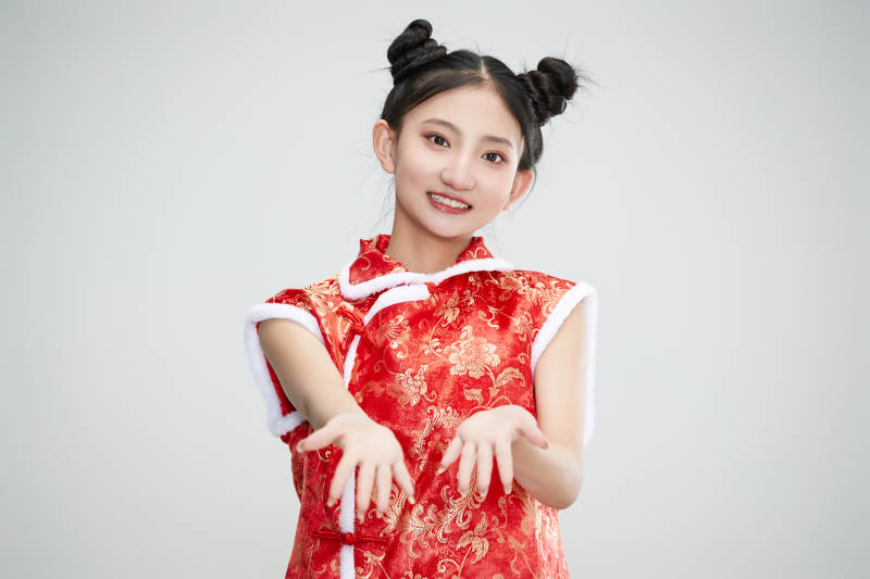 白色背景下身穿喜庆传统服饰的亚洲可爱少女图片