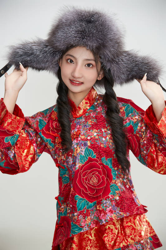 白色背景下穿中国传统服饰头戴绒帽的少女图片