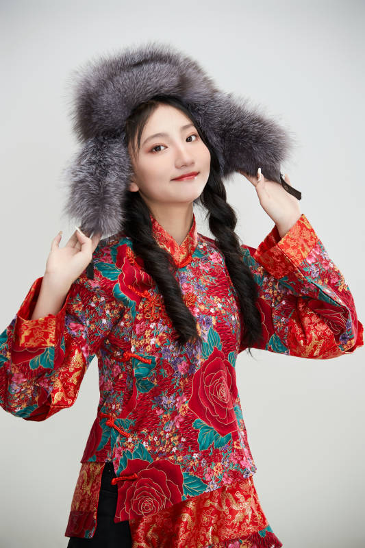 白色背景下穿中国传统服饰头戴绒帽的少女图片