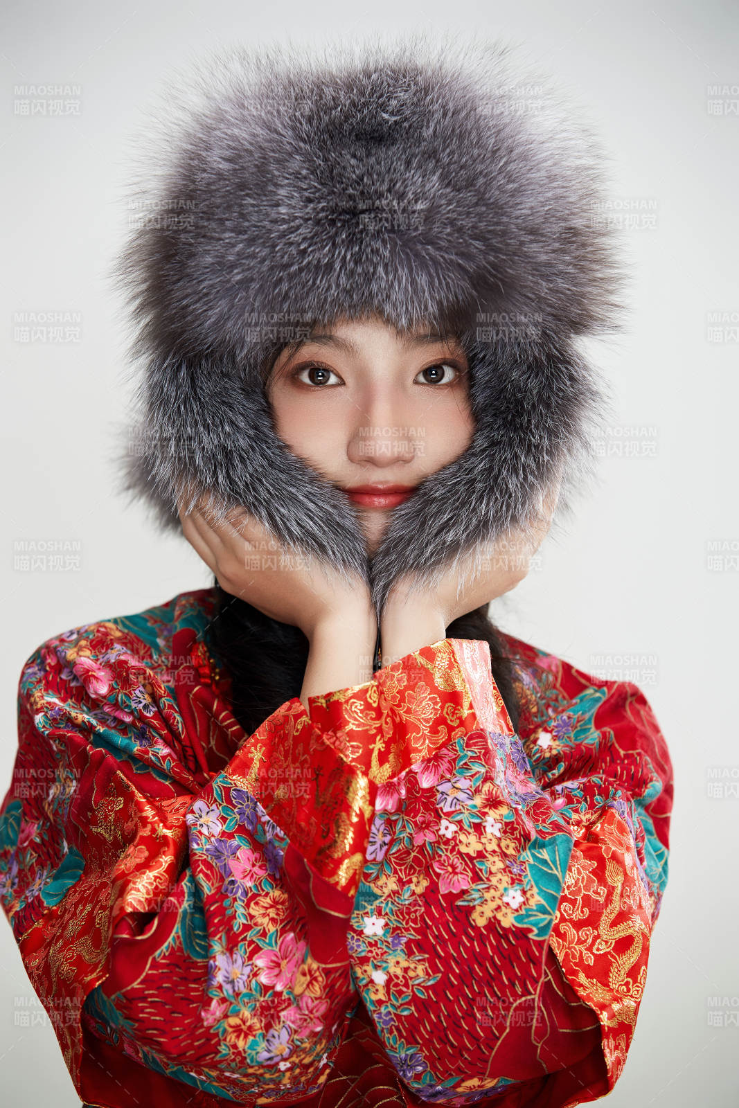 白色背景下穿中国传统服饰头戴绒帽的少女图片