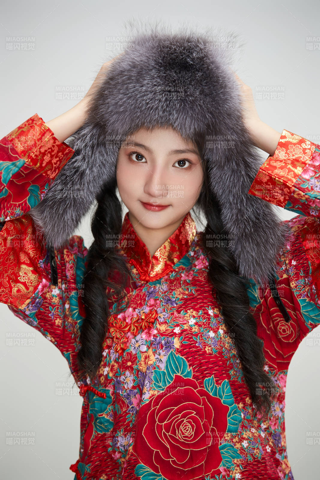 白色背景下穿中国传统服饰头戴绒帽的少女图片