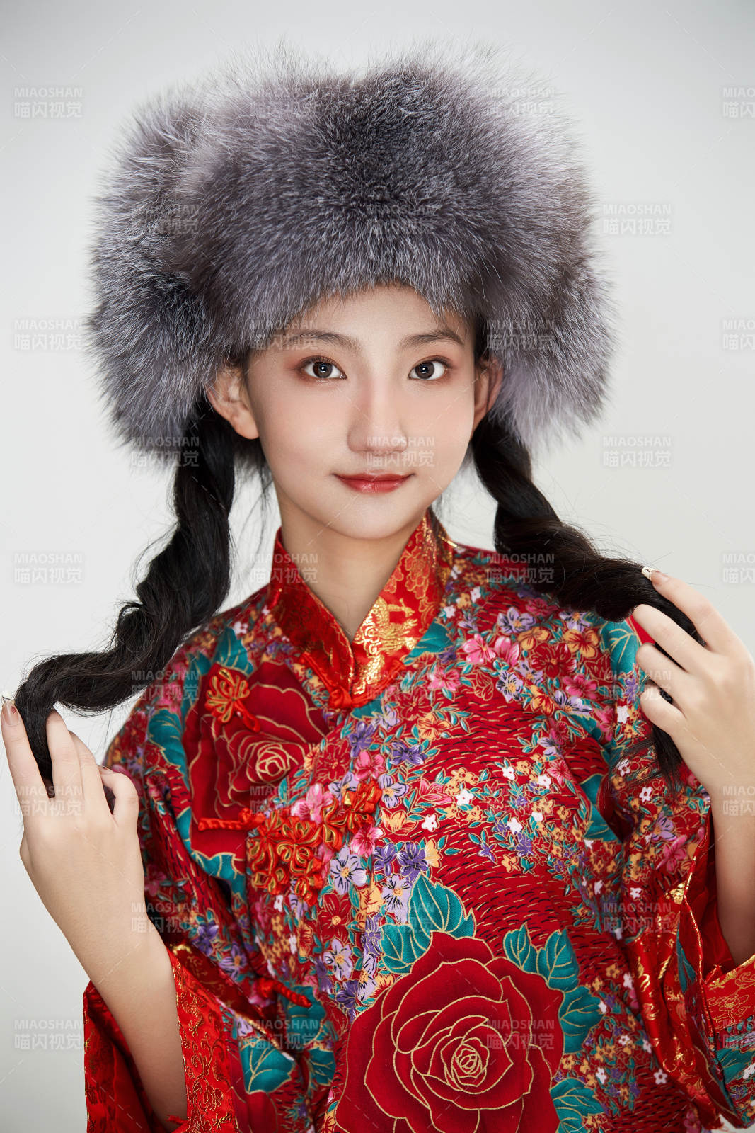白色背景下穿中国传统服饰头戴绒帽的少女图片