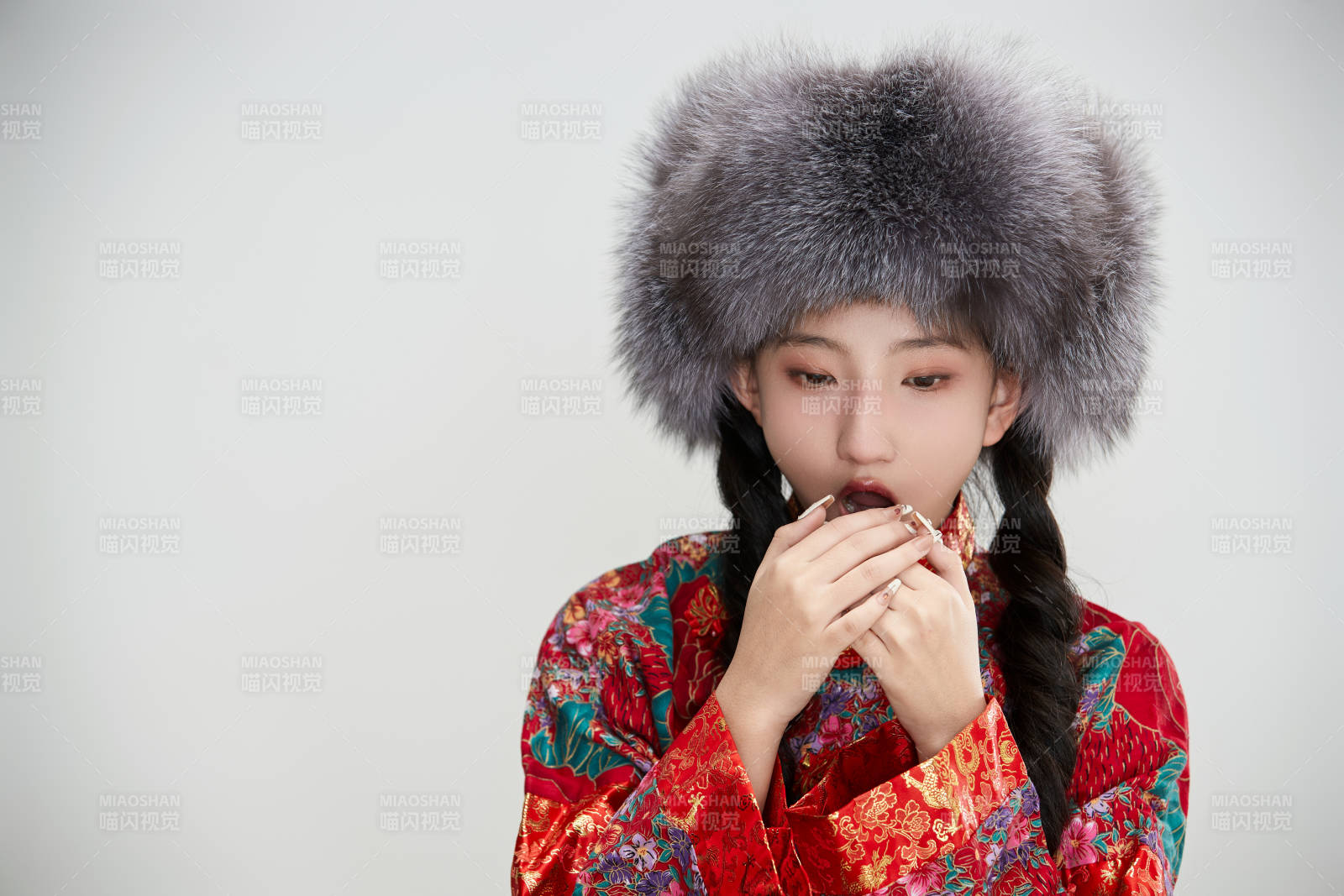 白色背景下穿中国传统服饰头戴绒帽的少女图片