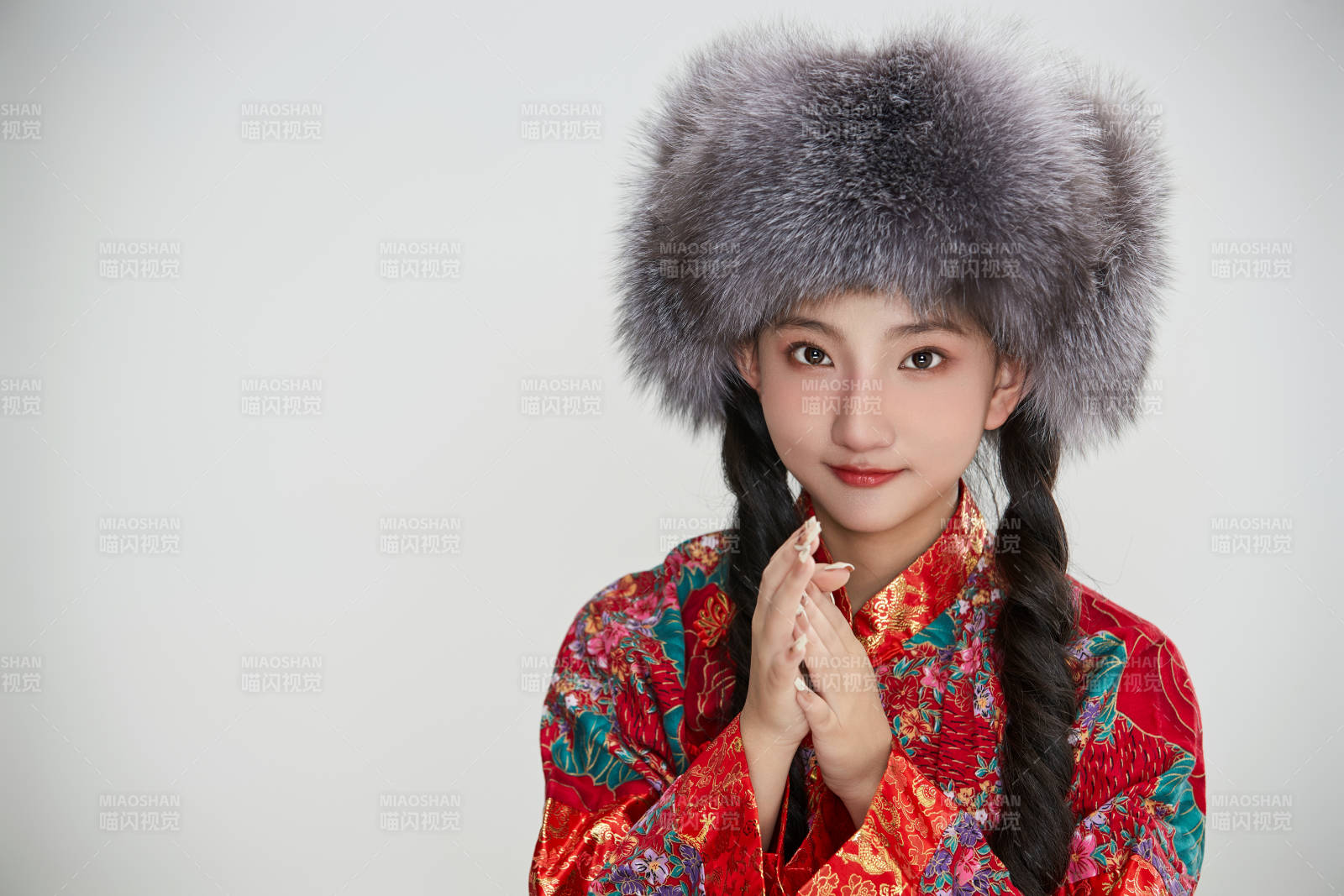 白色背景下穿中国传统服饰头戴绒帽的少女图片