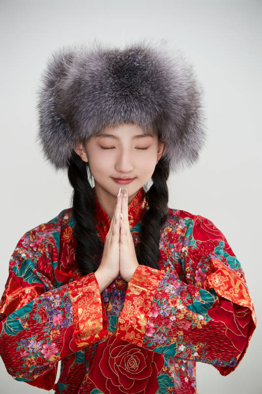 白色背景下穿中国传统服饰头戴绒帽的少女图片