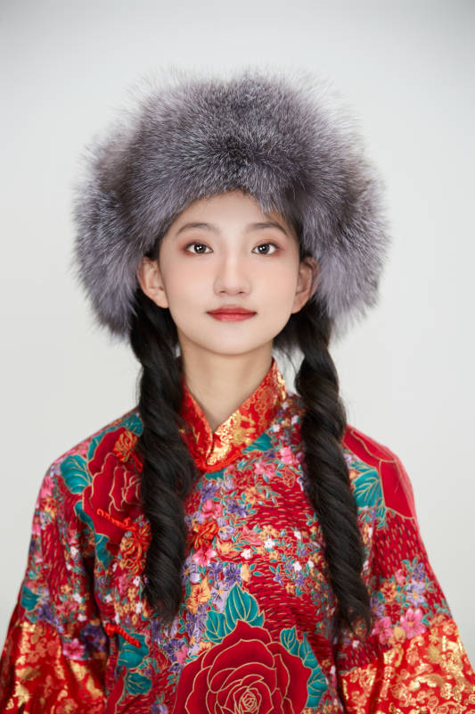 白色背景下穿中国传统服饰头戴绒帽的少女图片