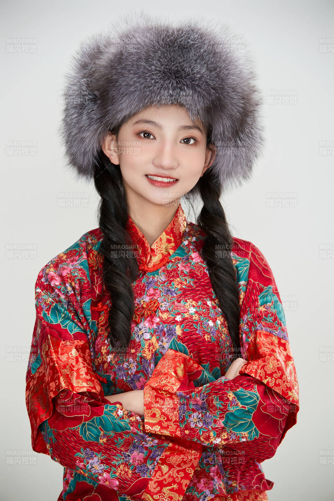 白色背景下穿中国传统服饰头戴绒帽的少女图片