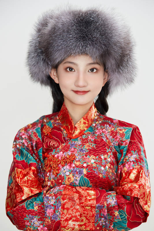 白色背景下穿中国传统服饰头戴绒帽的少女图片