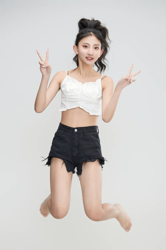 白色背景下腾空跳跃的可爱亚洲少女图片