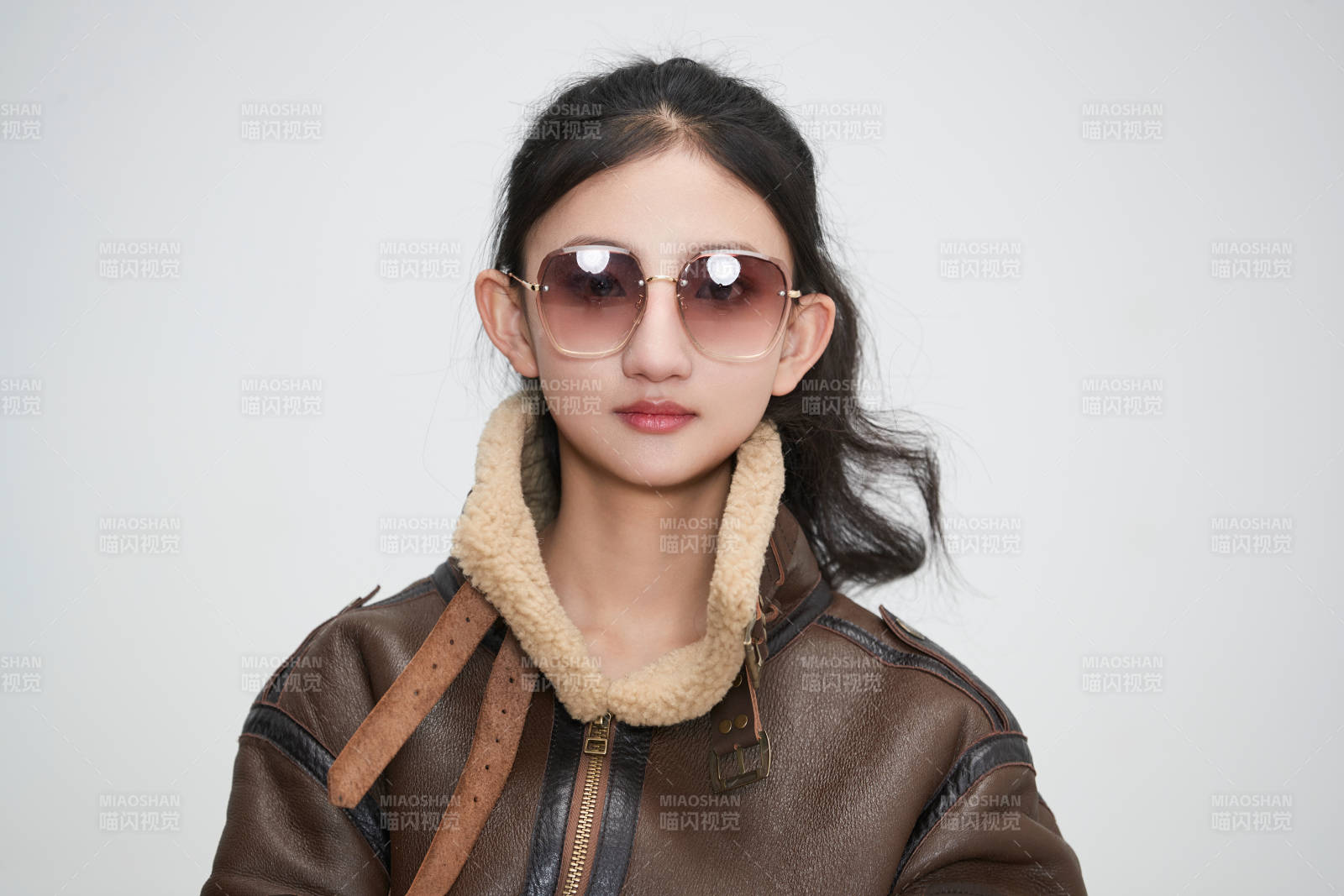 爱色背景下身穿飞行员皮夹克戴墨镜的可爱少女图片
