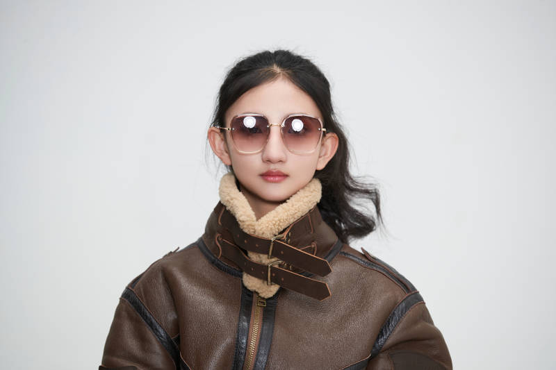 爱色背景下身穿飞行员皮夹克戴墨镜的可爱少女图片