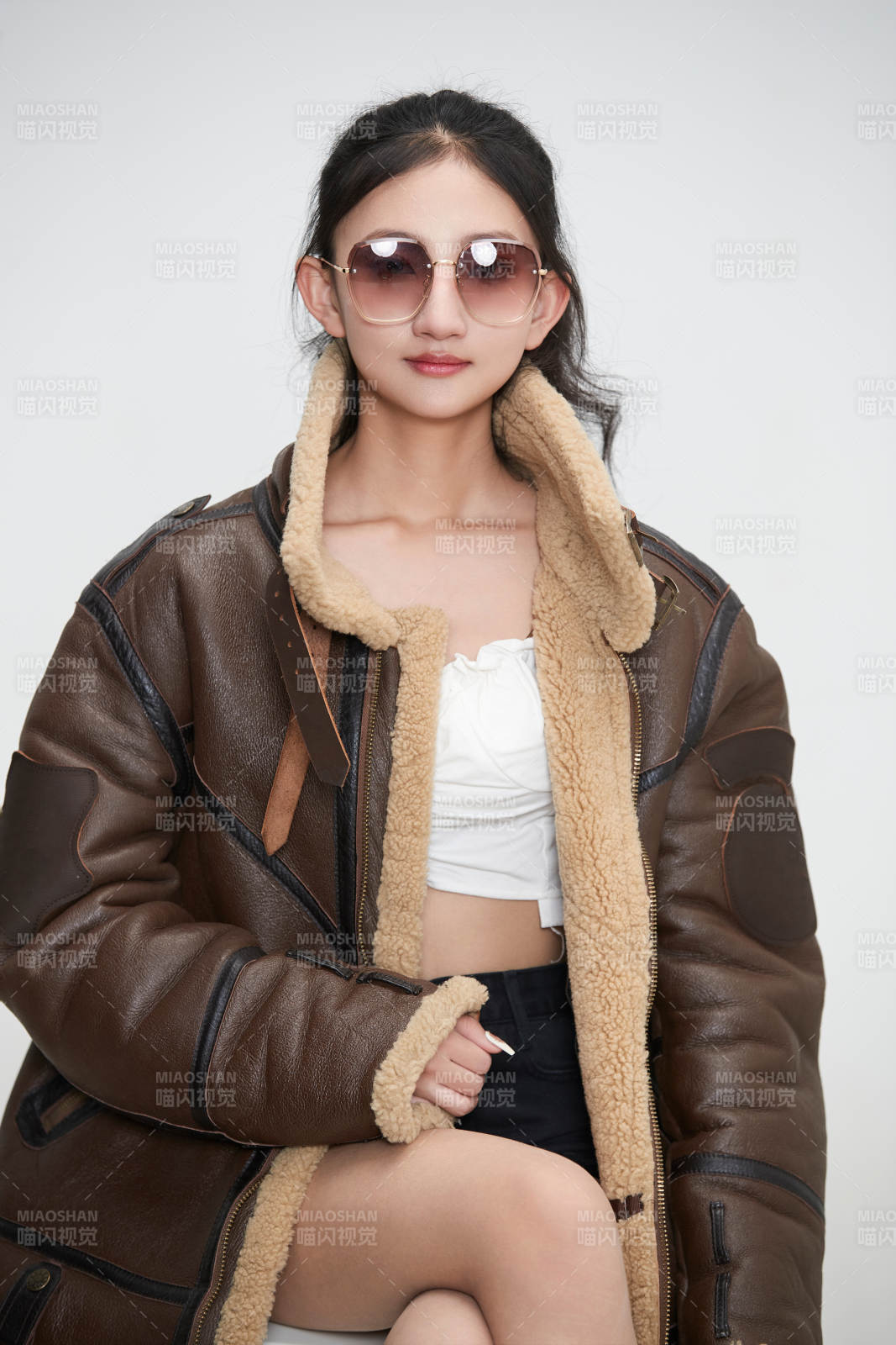 爱色背景下身穿飞行员皮夹克戴墨镜的可爱少女图片