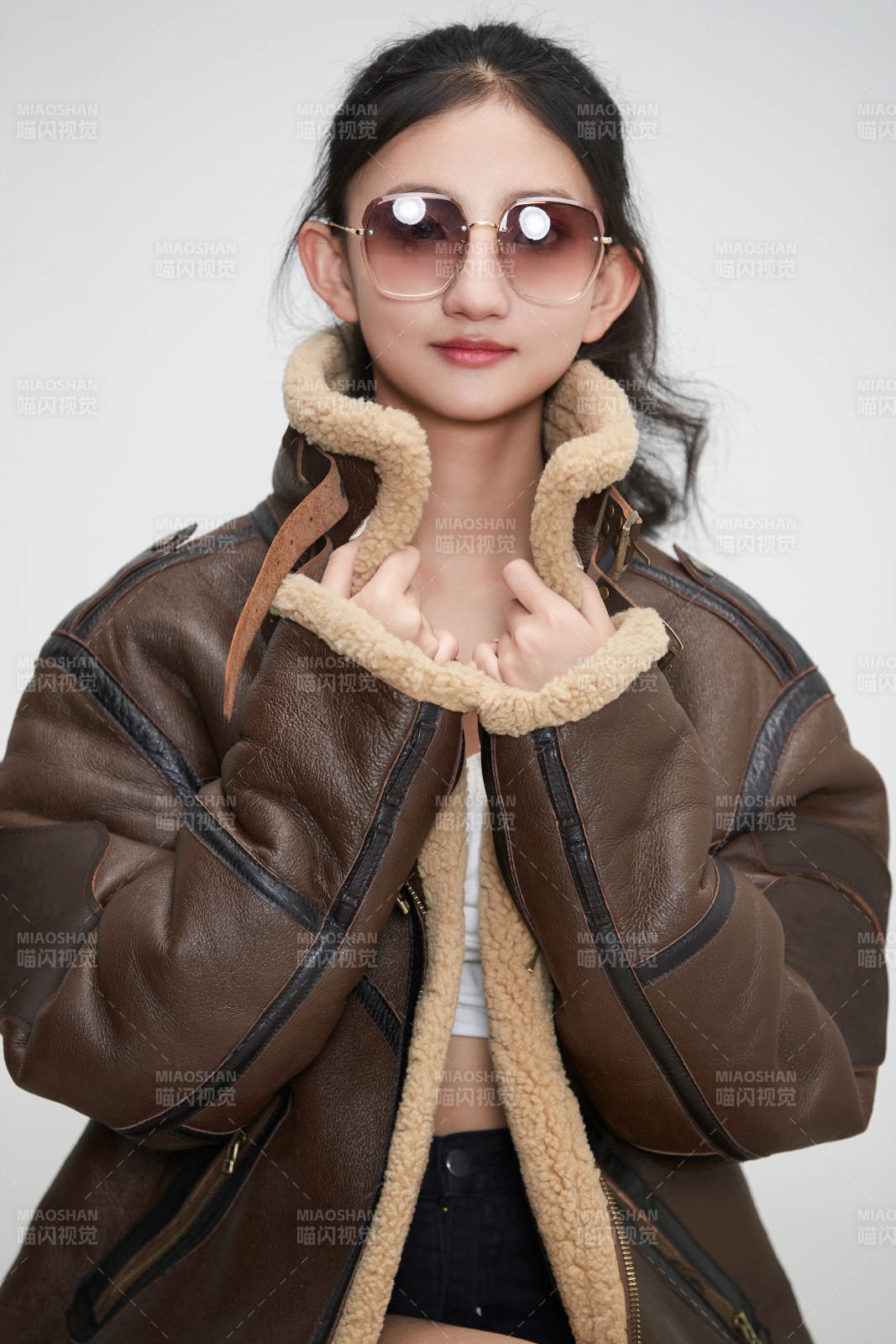 爱色背景下身穿飞行员皮夹克戴墨镜的可爱少女图片