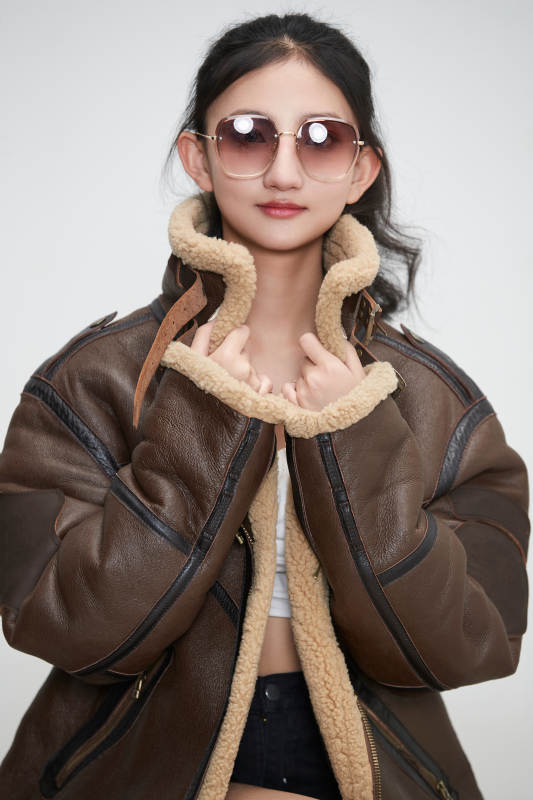 爱色背景下身穿飞行员皮夹克戴墨镜的可爱少女图片