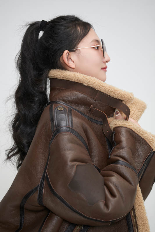 爱色背景下身穿飞行员皮夹克戴墨镜的可爱少女图片